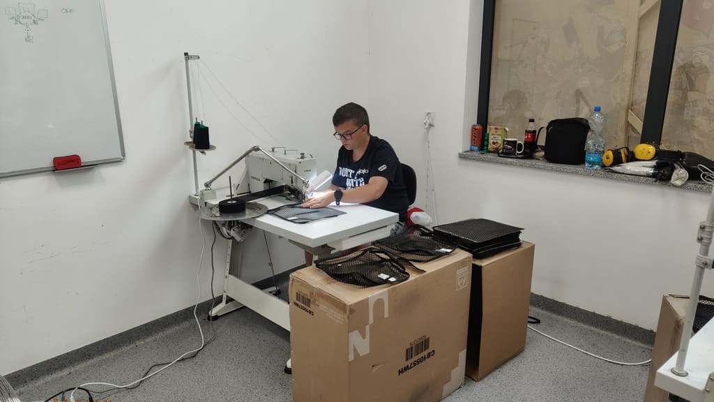 Uczestnik pracowni szyje przy maszynie w warsztacie